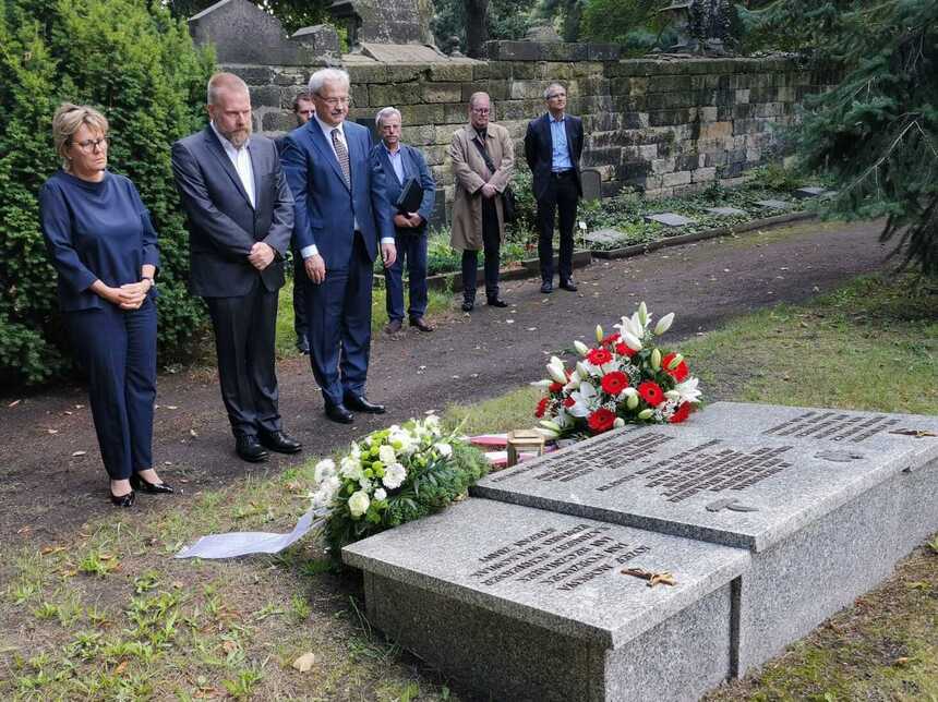 Barbara Klepsch, Piotr Golema und Markus Pieper vor den Gräbern in stillem Gedenken