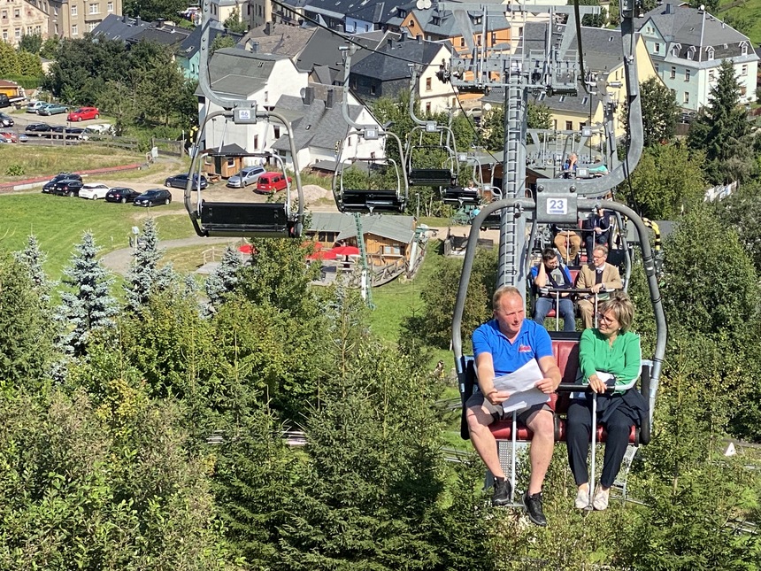 Tourismusministerin Barbara Klepsch übergibt auf einem Sessellift in Eibenstock einen Förderbescheid.