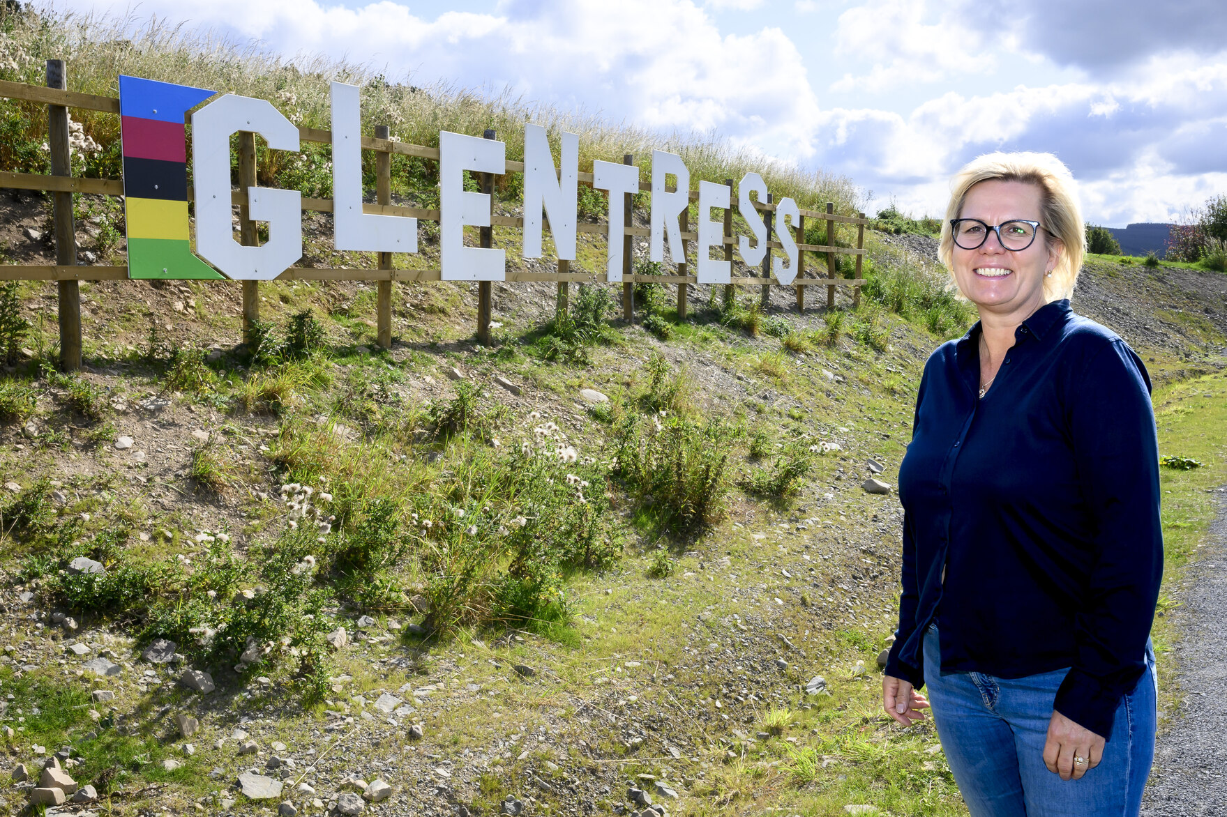 Die Ministerin vor einem großen Glentress Schild 