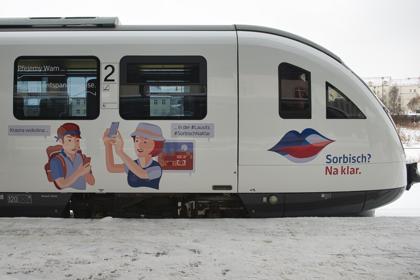 Das Foto zeigt den Triebwagen mit dem Kampagnenmotiv Sorbisch Na Klar.